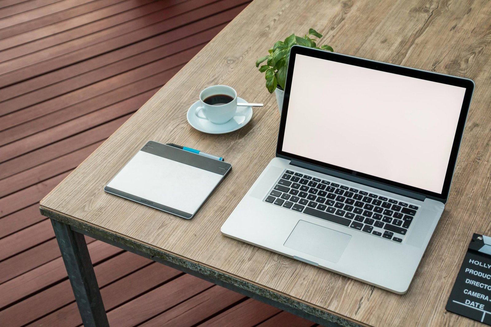 Modern laptop on a wooden table next to a coffee mug, representing managed IT work in a small business environment.
