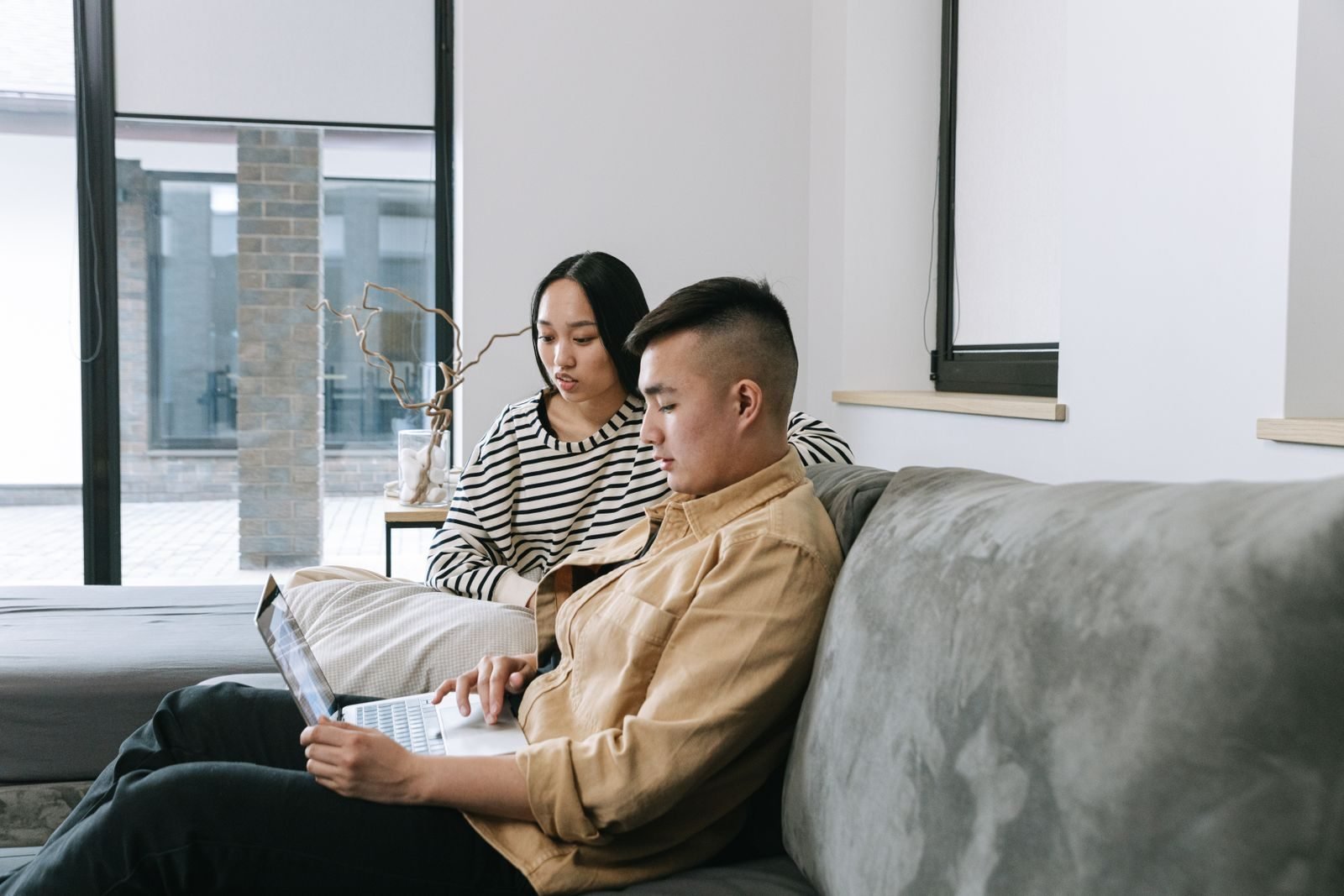 Couple enjoying seamless whole-home Wi-Fi coverage on a laptop in a modern living room